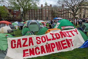 2024 Gaza Solidarity Encampment at Brown University, showing a tent encampment with a white panel and red letters reading "Gaza Solidarity Encampment"