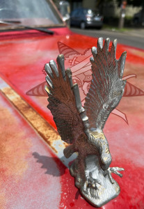 An eagle hood ornament with the Self Help Radio logo nearby.