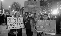 Protests against the Trump regime in London on January 30th, 2017 signs say "Resist fascism". "Who's the enemy? White Supremacy", and "We the people will stand in unity against your regime, your racism, your classism, and your sexism."